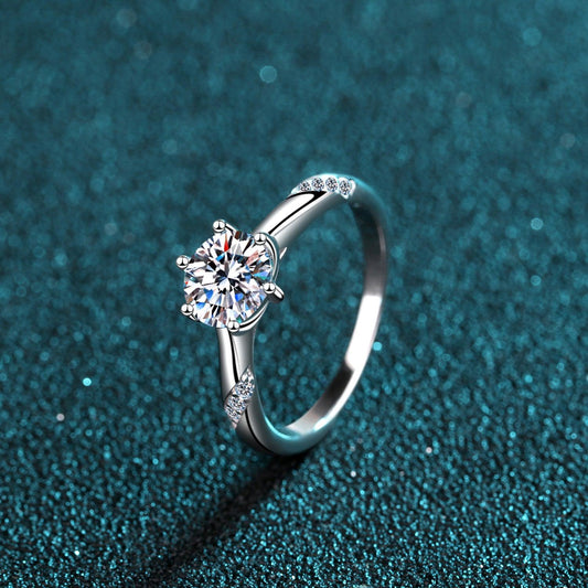 Elegant diamond engagement ring set on a sparkling teal background