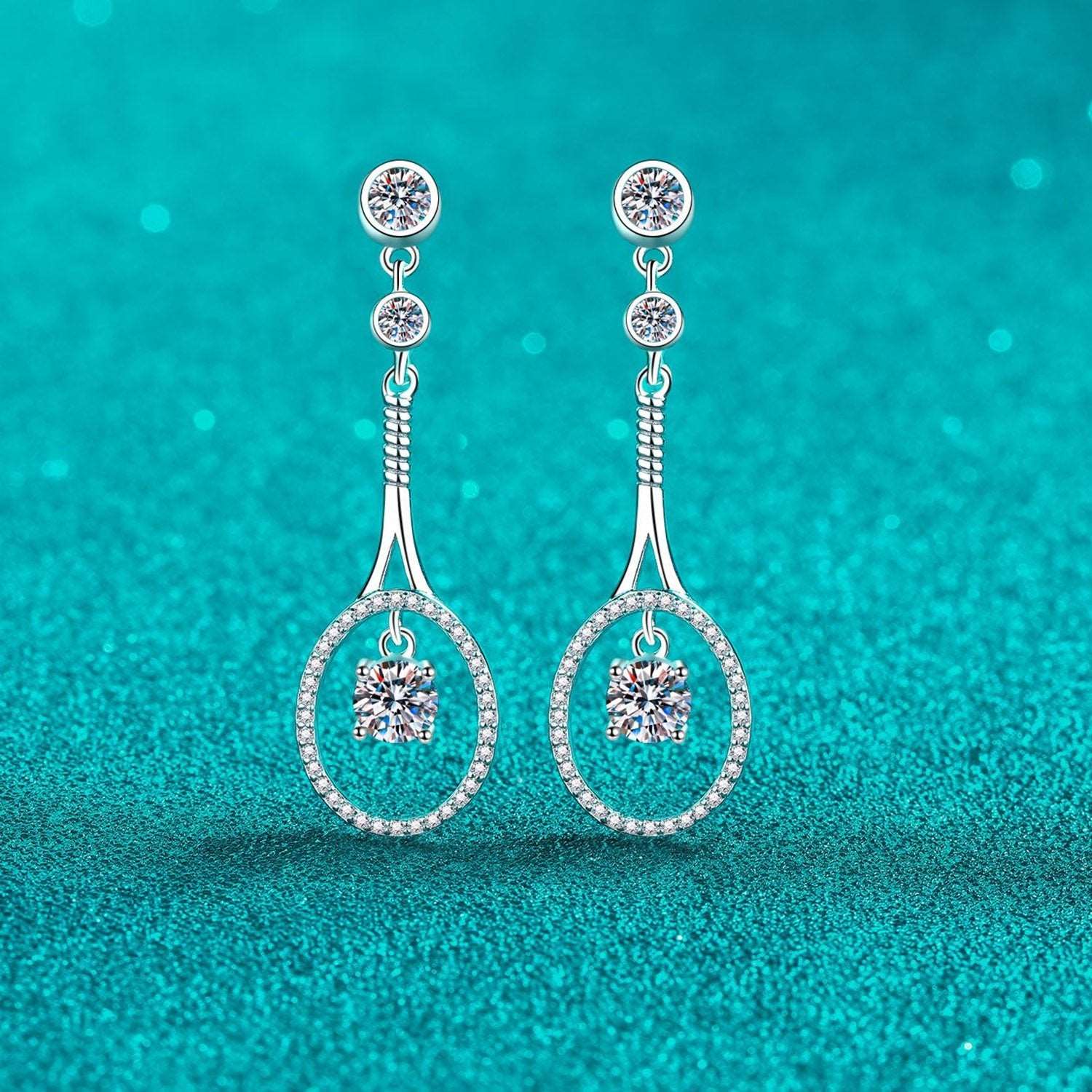 Elegant 1 Carat Moissanite Sterling Silver Drop Earrings on a vibrant turquoise background