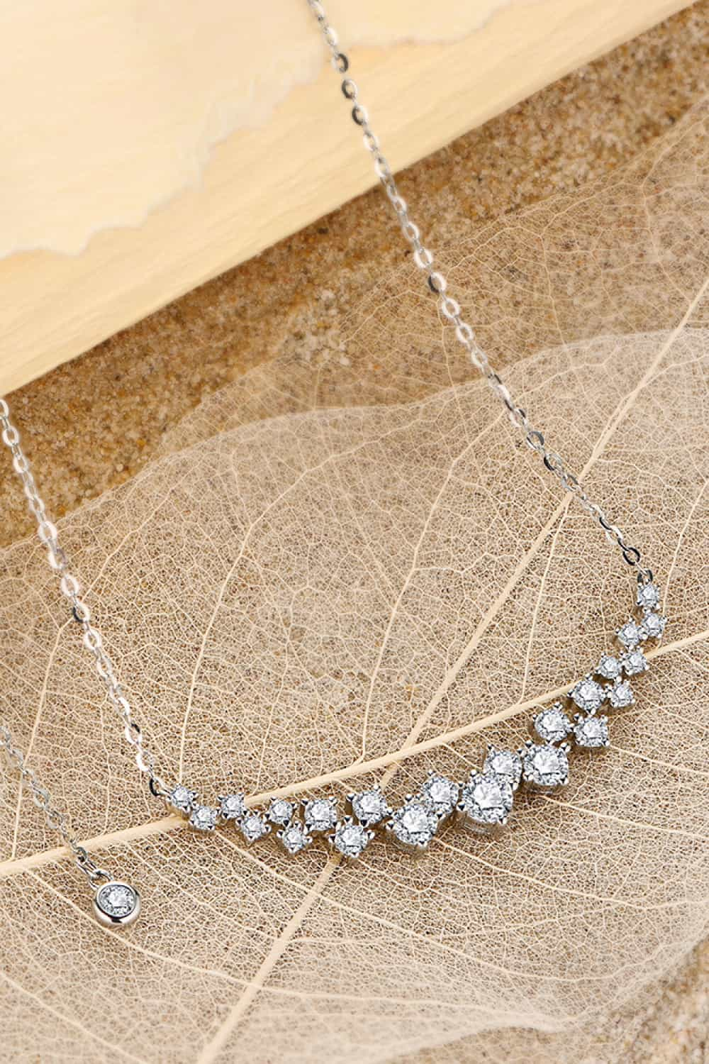 Elegant 1.64 Carat Moissanite 925 Sterling Silver Necklace on Textured Brown Background