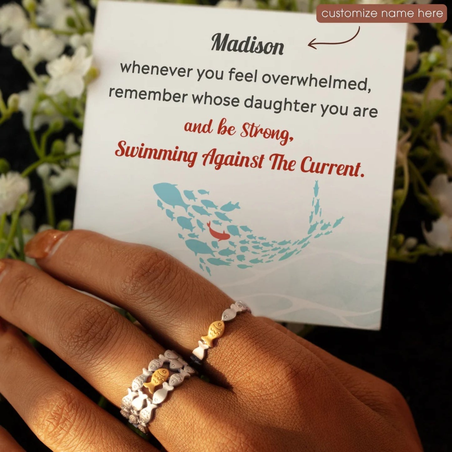 a woman's hand holding a sign with a ring on it