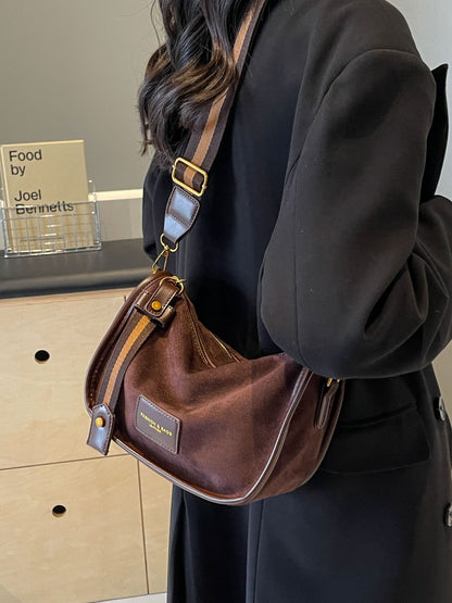 a woman in a black coat is holding a brown purse