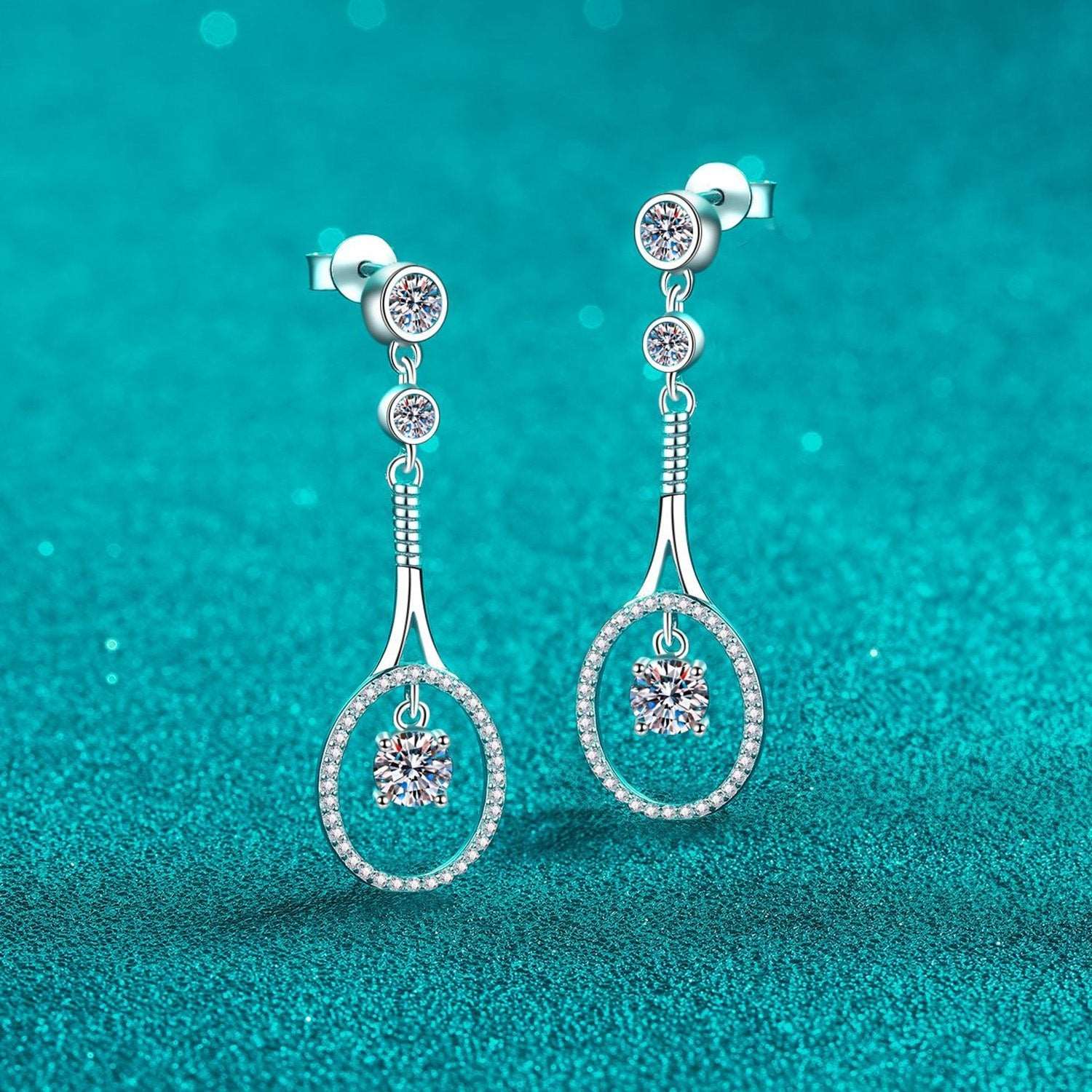 Elegant drop diamond earrings on teal background