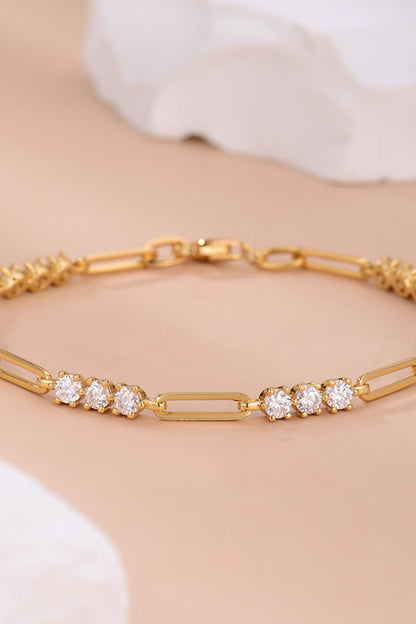 Elegant gold bracelet with sparkling rhinestones. Delicate link chain design adorned with round crystal accents. Fashionable jewelry piece in a close-up product image.