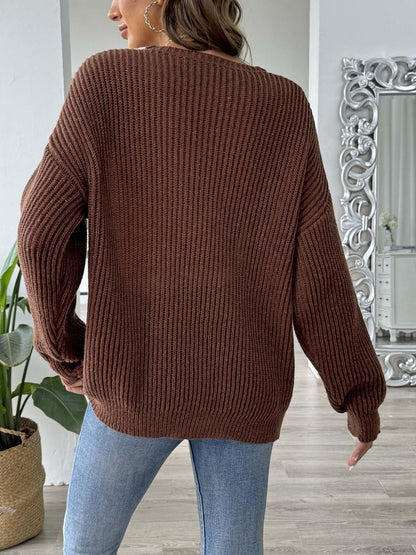 a woman wearing a brown sweater and jeans