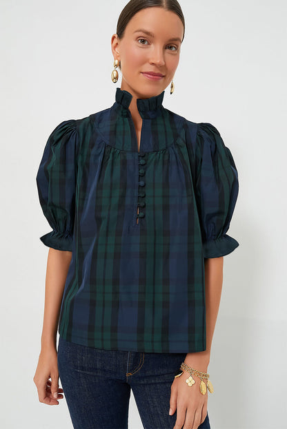 a woman wearing a green and black plaid shirt