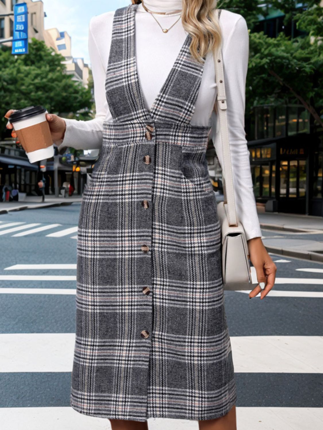 a woman standing on a street holding a cup of coffee