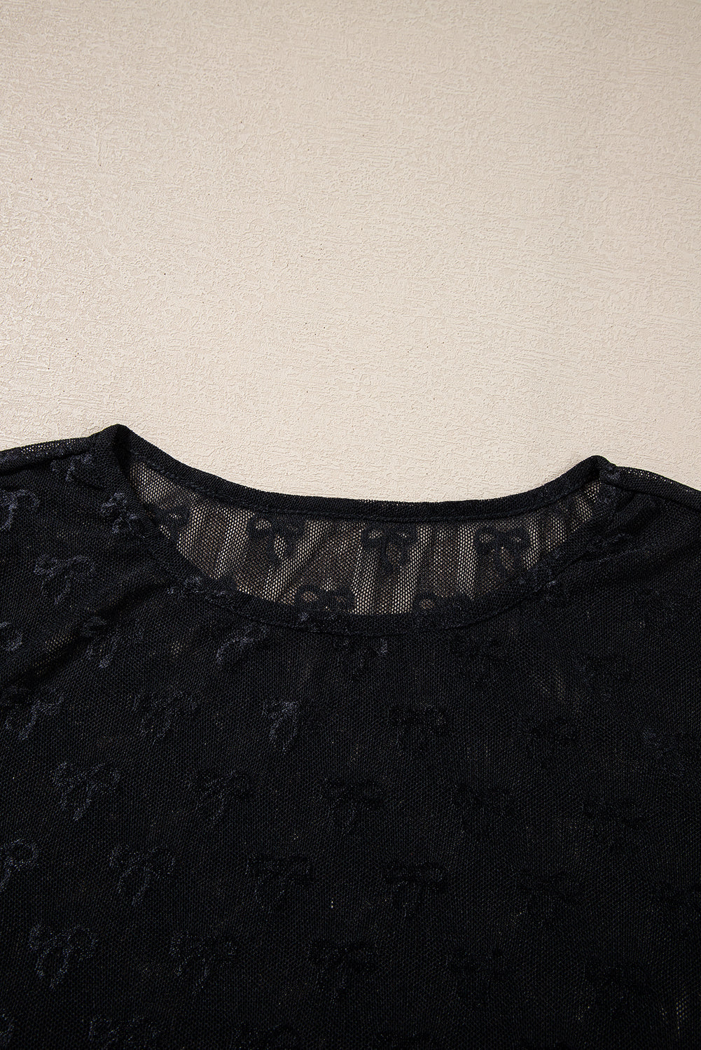 a woman's black top with a sheer neckline