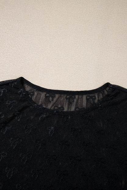 a woman's black top with a sheer neckline