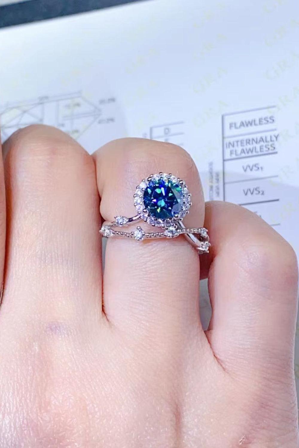 Elegant blue moissanite solitaire ring with diamond accents on hand