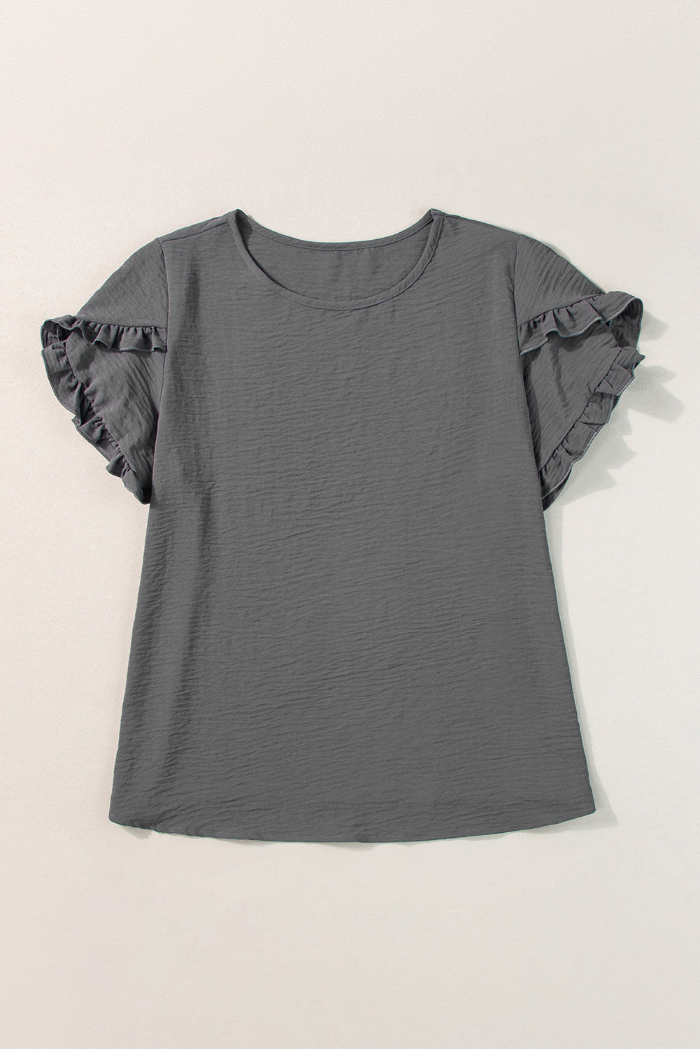 a gray shirt with ruffled sleeves on a hanger