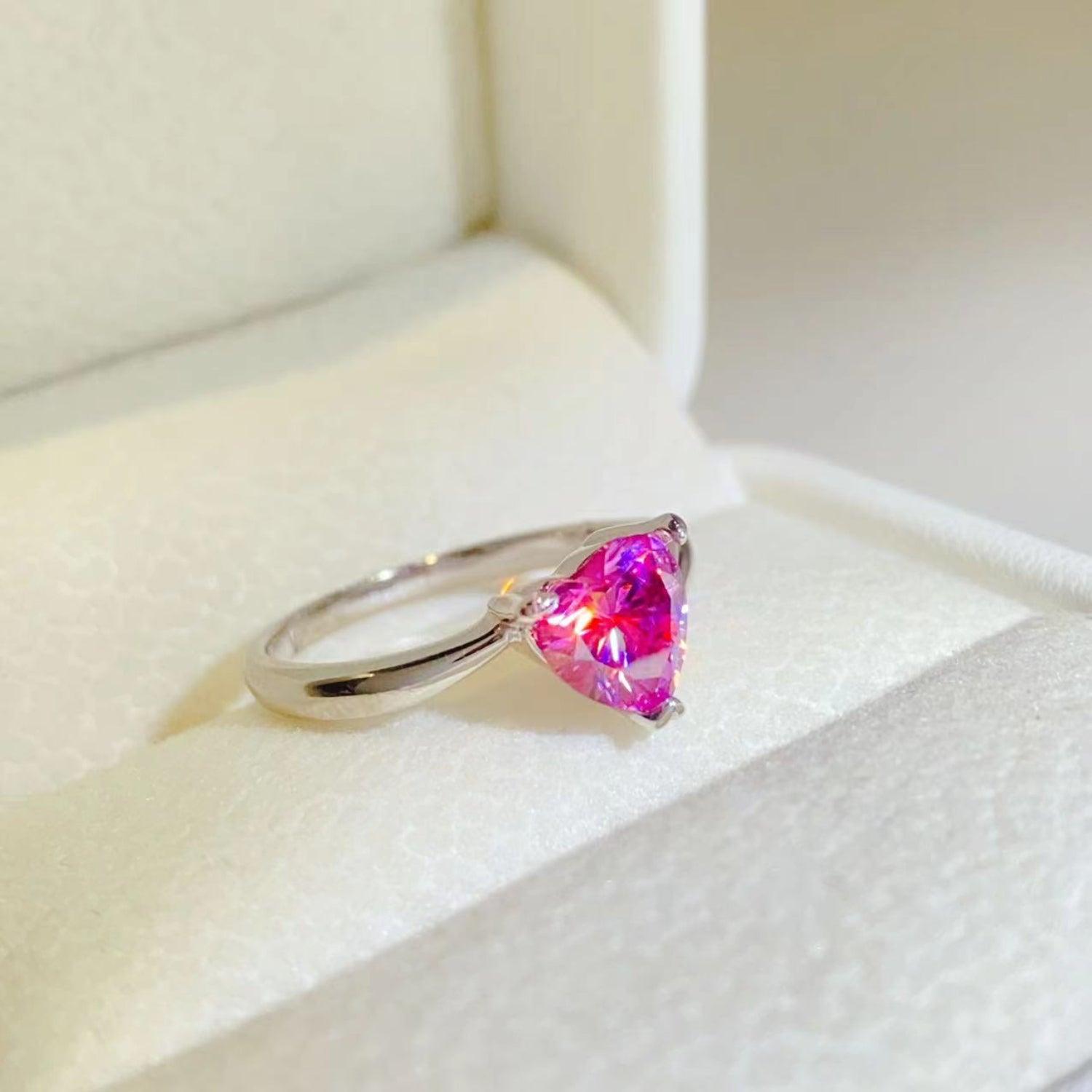 Stunning 1 Carat Moissanite 925 Sterling Silver Ring with a vibrant heart-shaped pink gemstone, presented on a soft white surface.