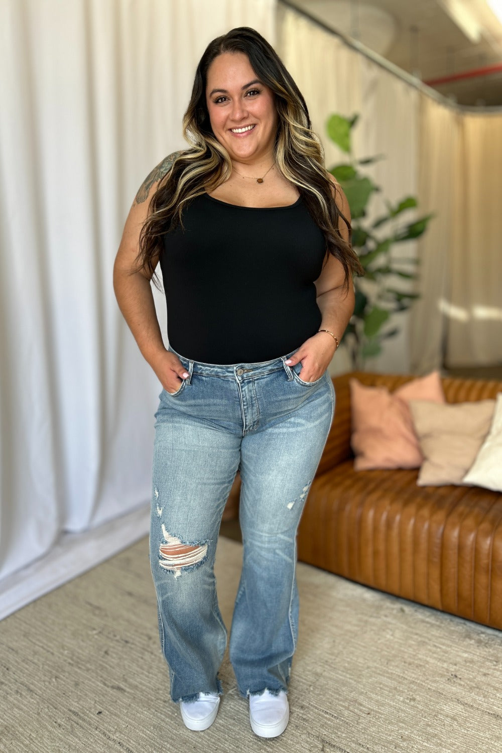 a woman standing in a living room with her hands on her hips