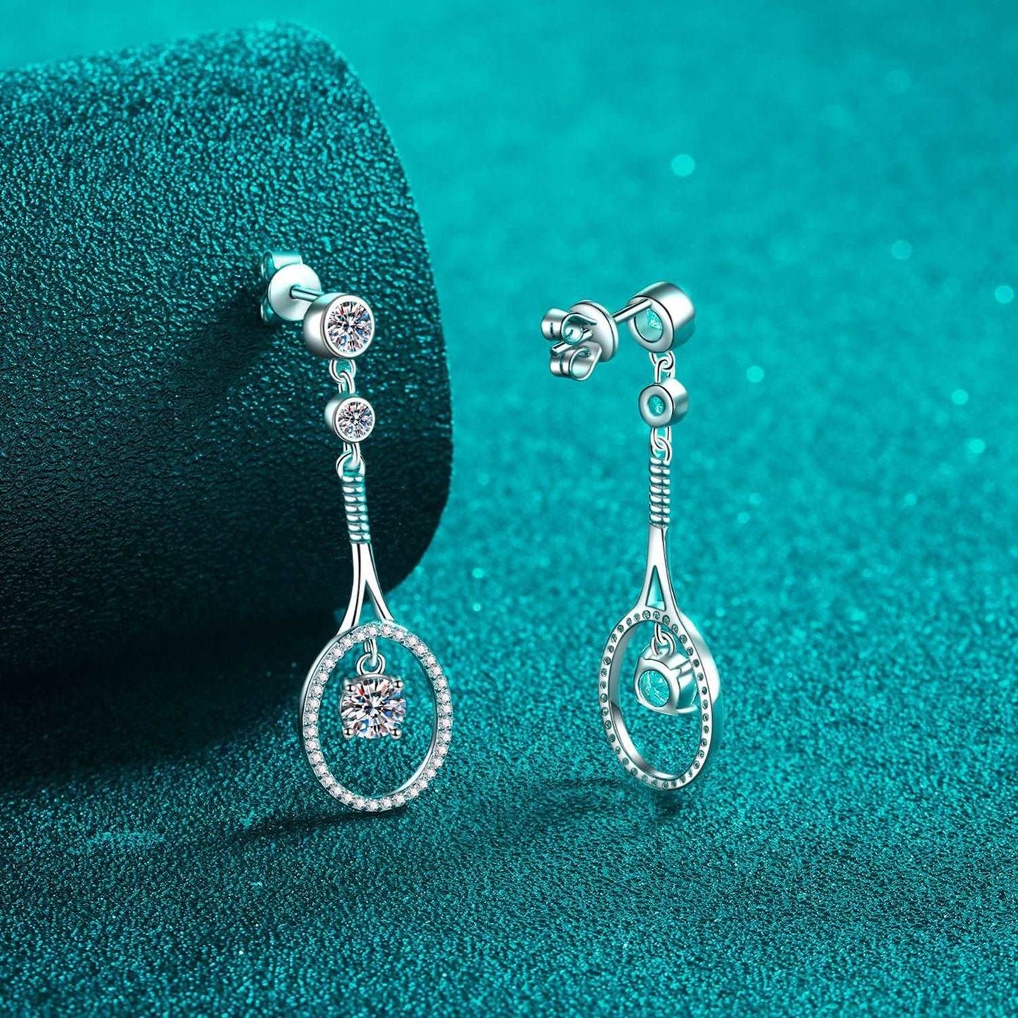 Elegant diamond-encrusted drop earrings on emerald green background