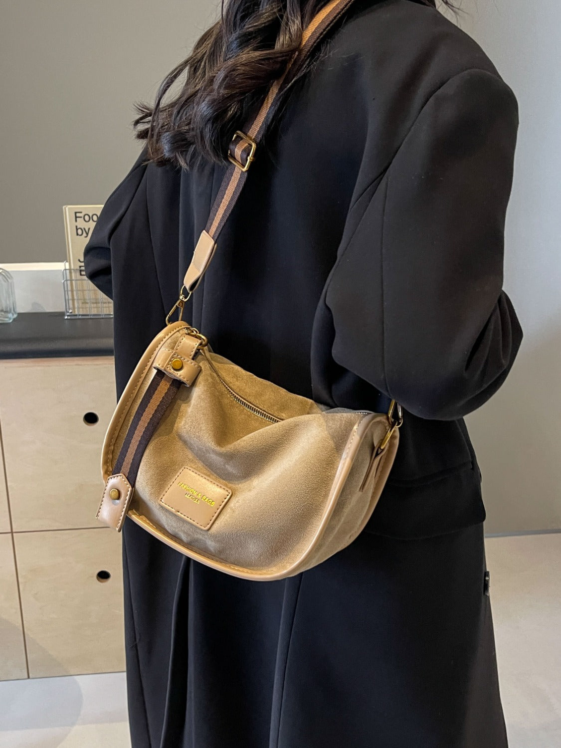 a woman in a black dress holding a beige purse