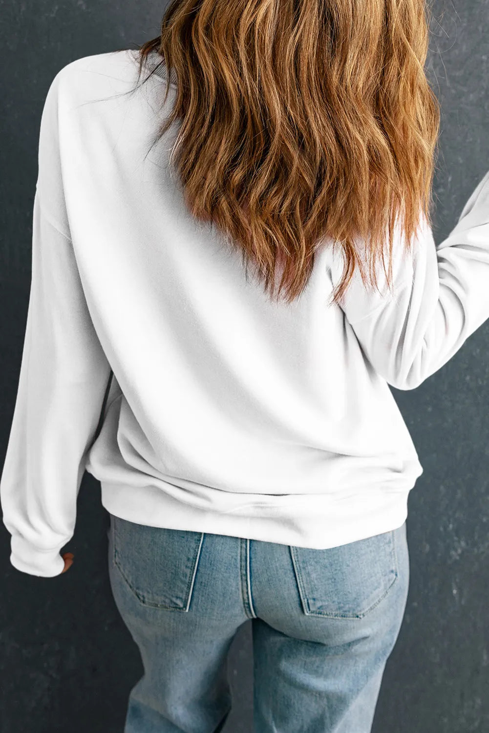 the back of a woman's head wearing a white sweatshirt