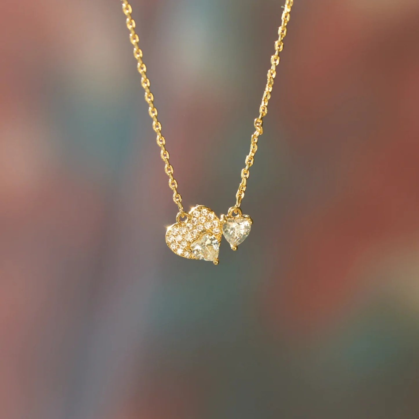 a gold necklace with a heart and a bow