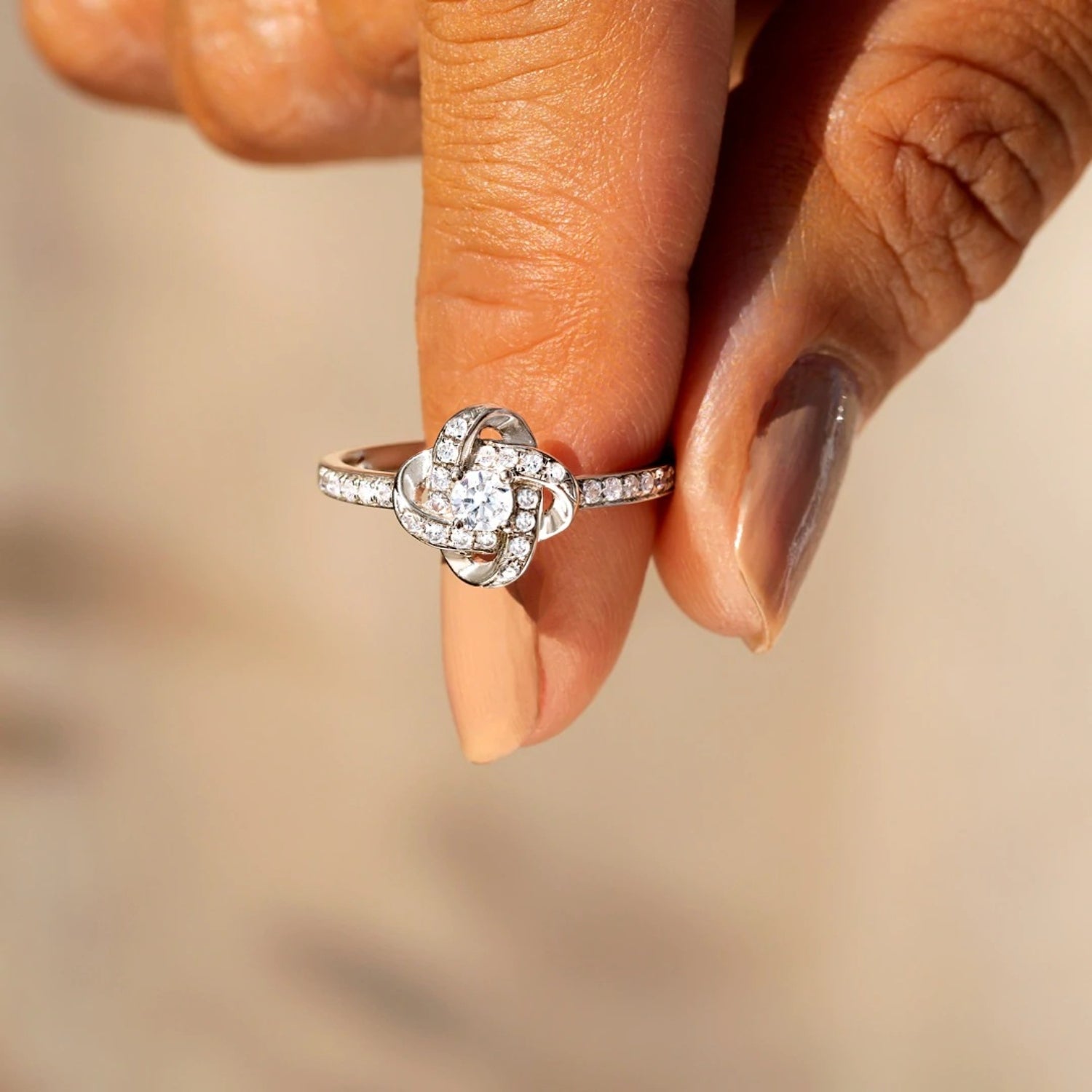 a woman's hand holding a diamond ring