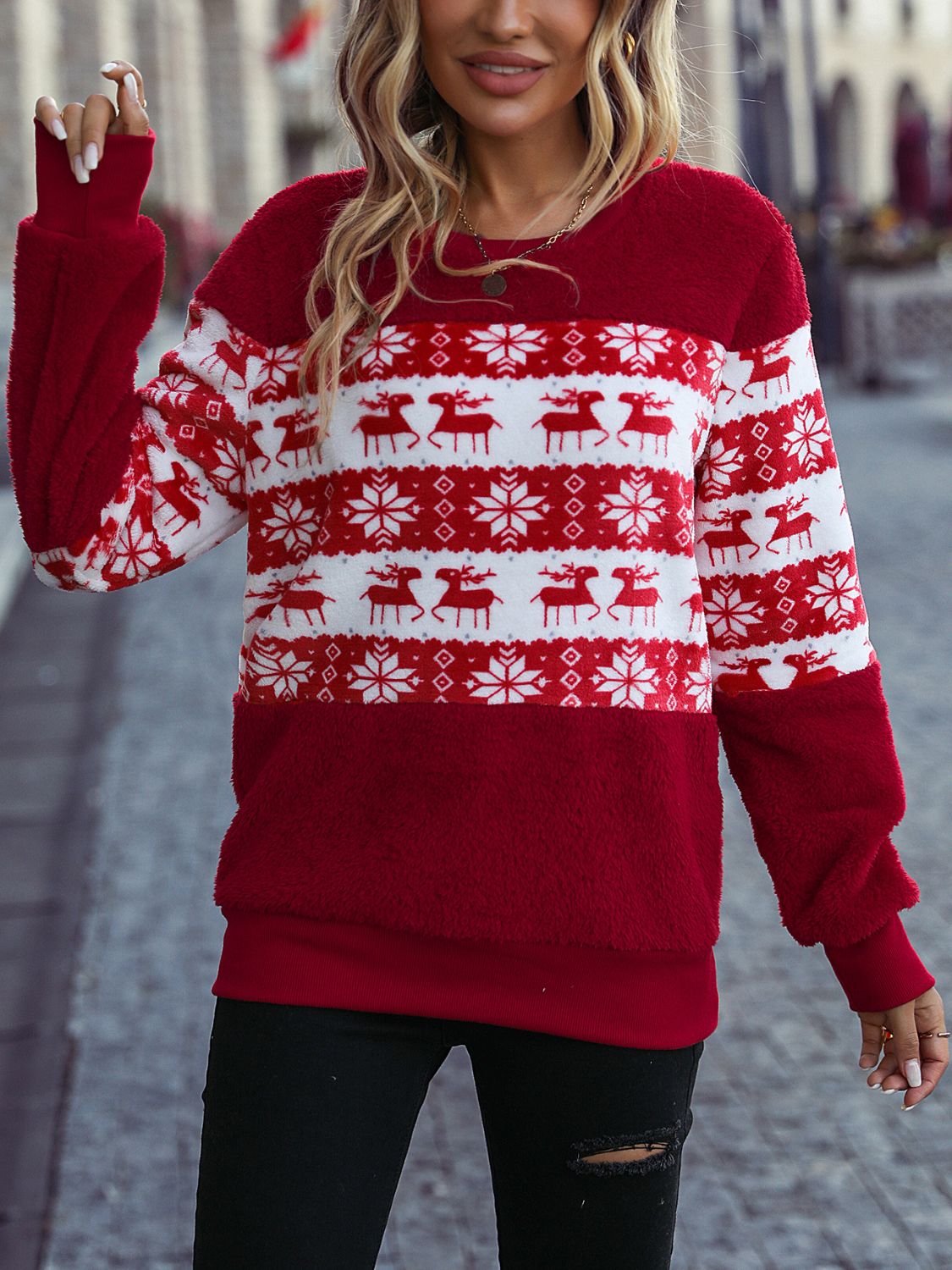 a woman wearing a red and white christmas sweater