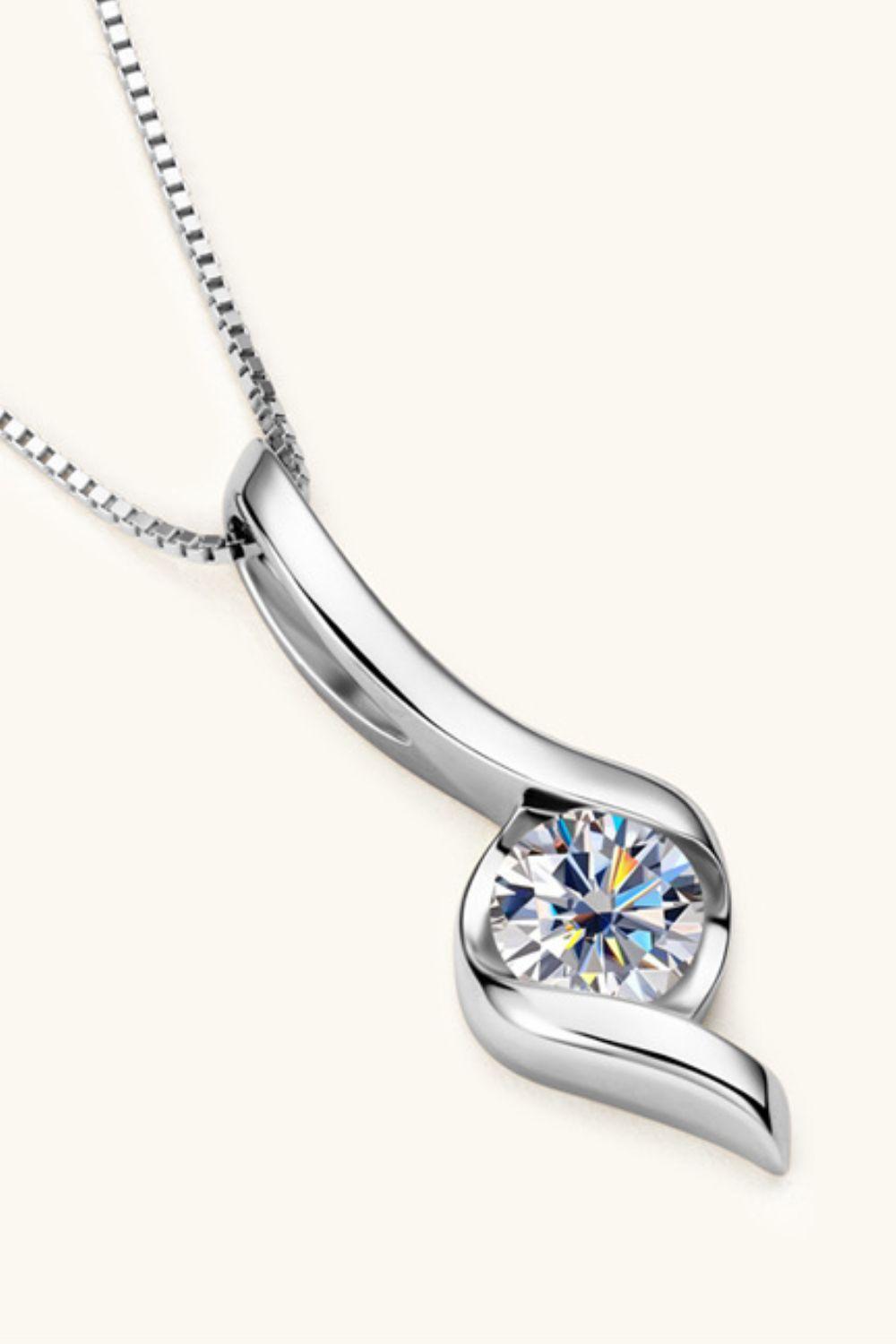 Elegant 1 carat moissanite pendant on silver chain, showcasing a sparkling gemstone against a minimalist background.