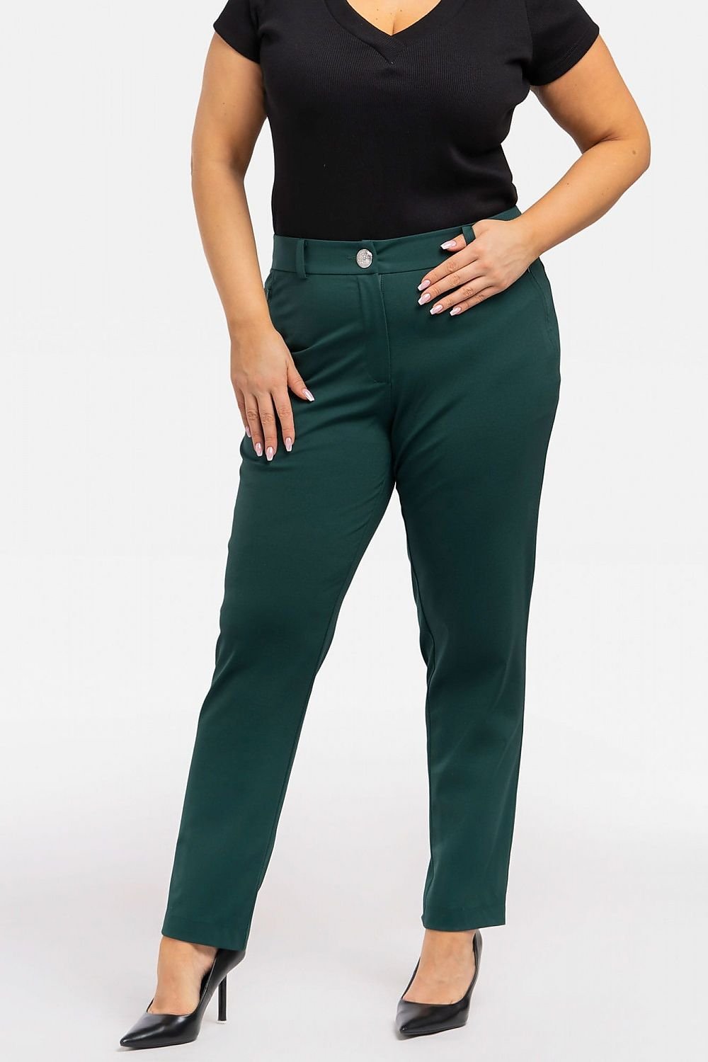 a woman in a black top and green pants