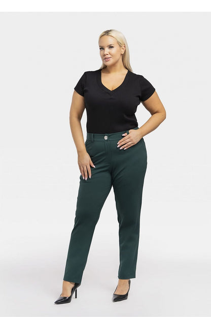 a woman in a black top and green pants