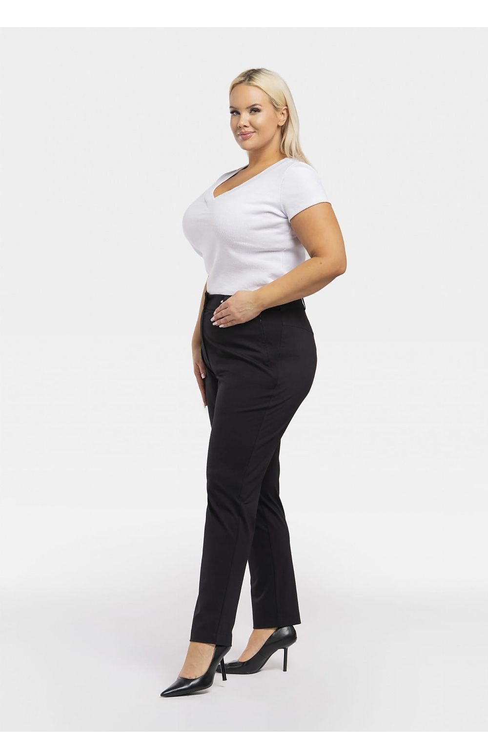 a woman in a white top and black pants