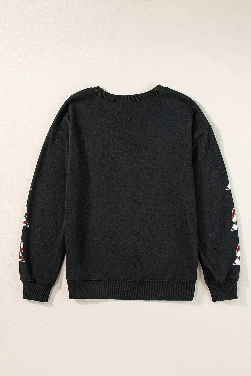 a black sweatshirt with white and red flowers on the sleeves