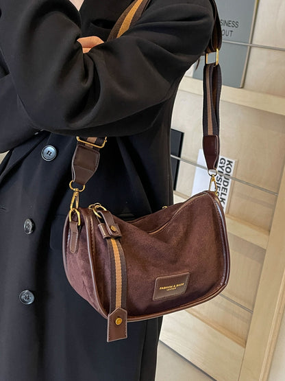 a woman in a black coat holding a brown purse