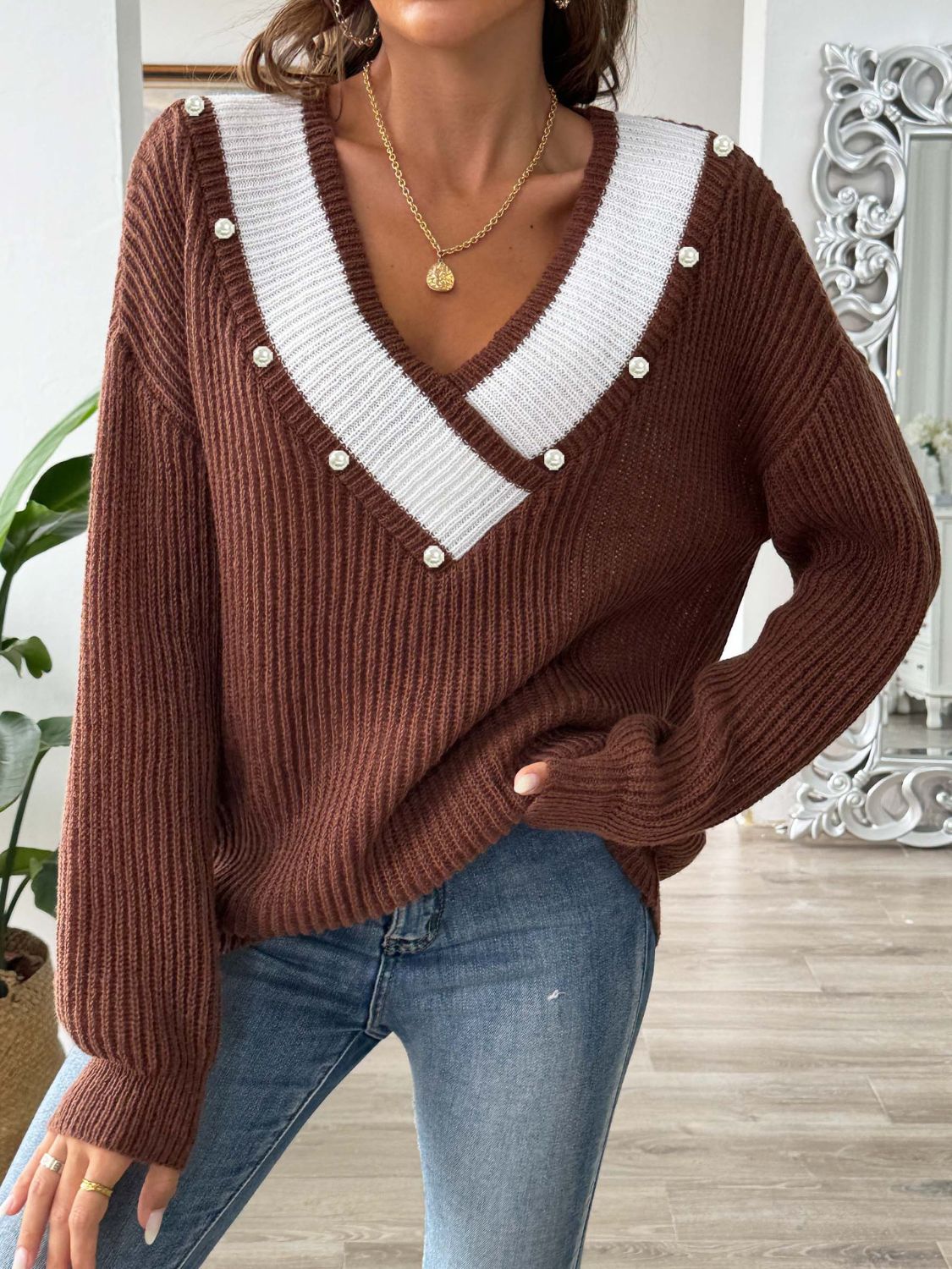 a woman wearing a brown sweater and jeans