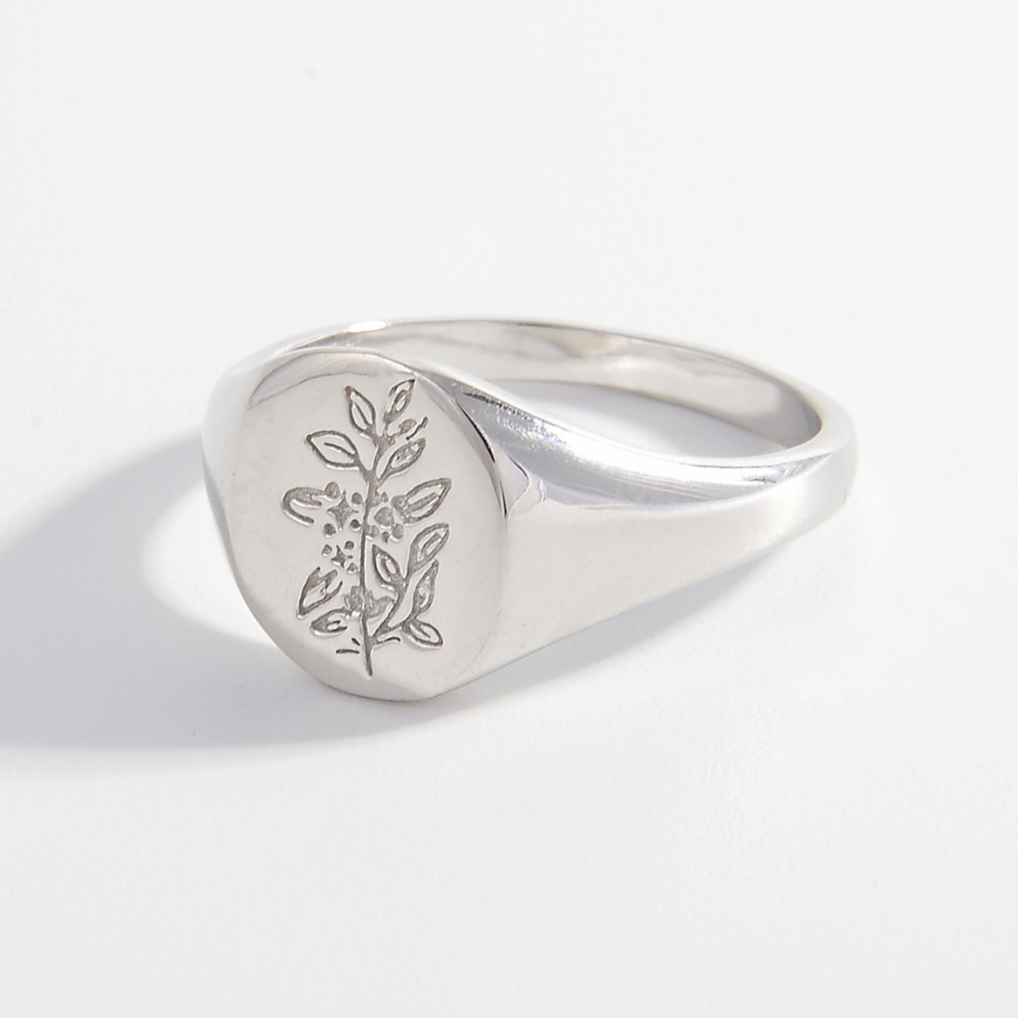 a silver signet ring with a tree on it