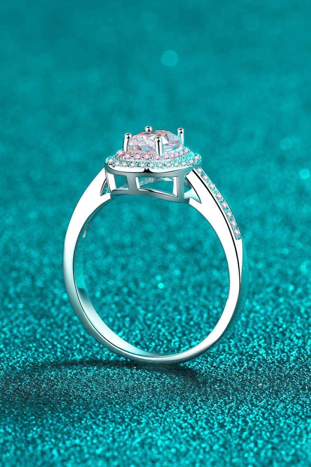 Sparkling 1 Carat Moissanite Halo Ring on Teal Glitter Background