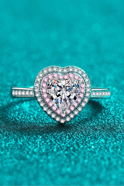 Elegant heart-shaped moissanite ring with sparkling diamond halo on teal background