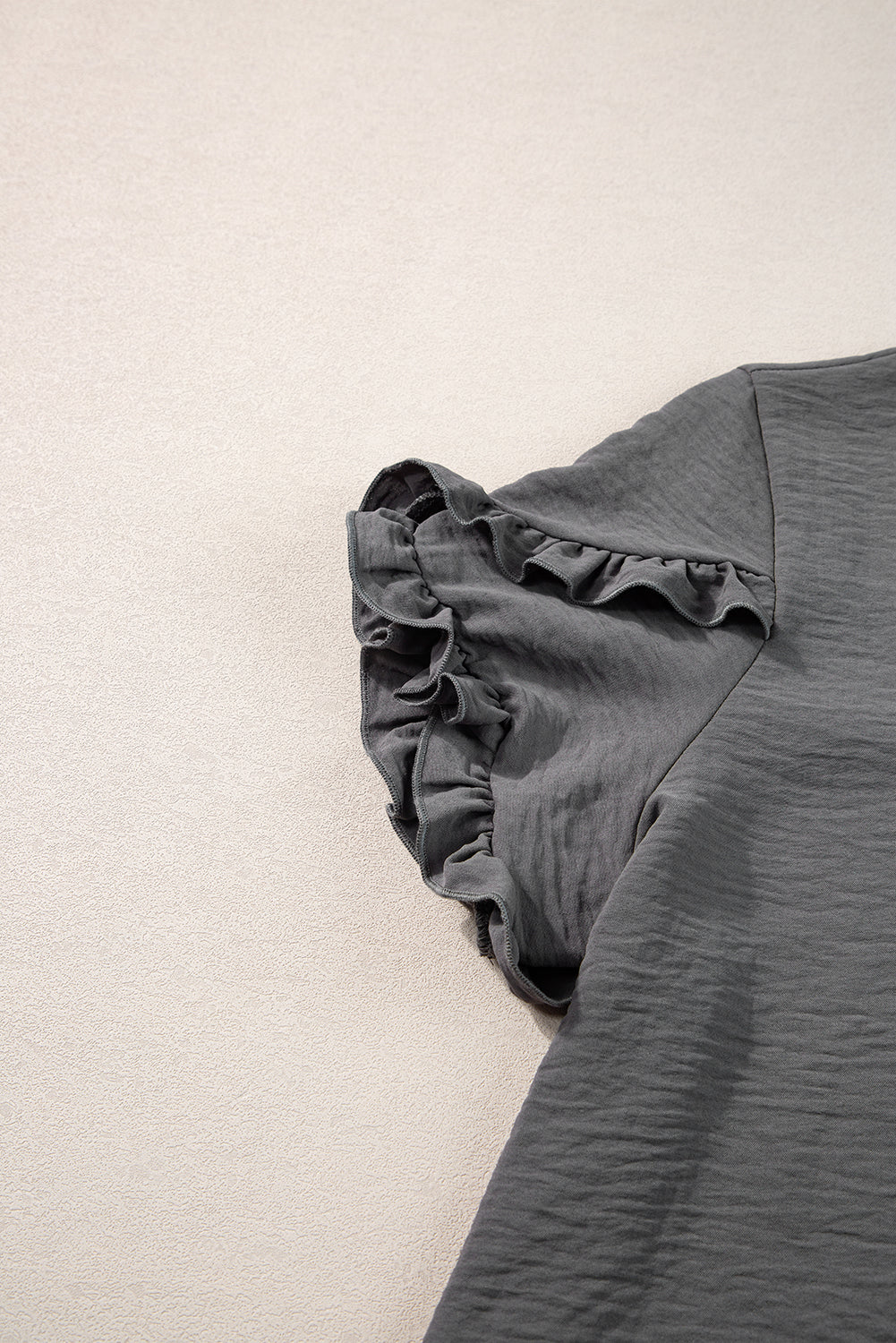 a black shirt laying on a white floor