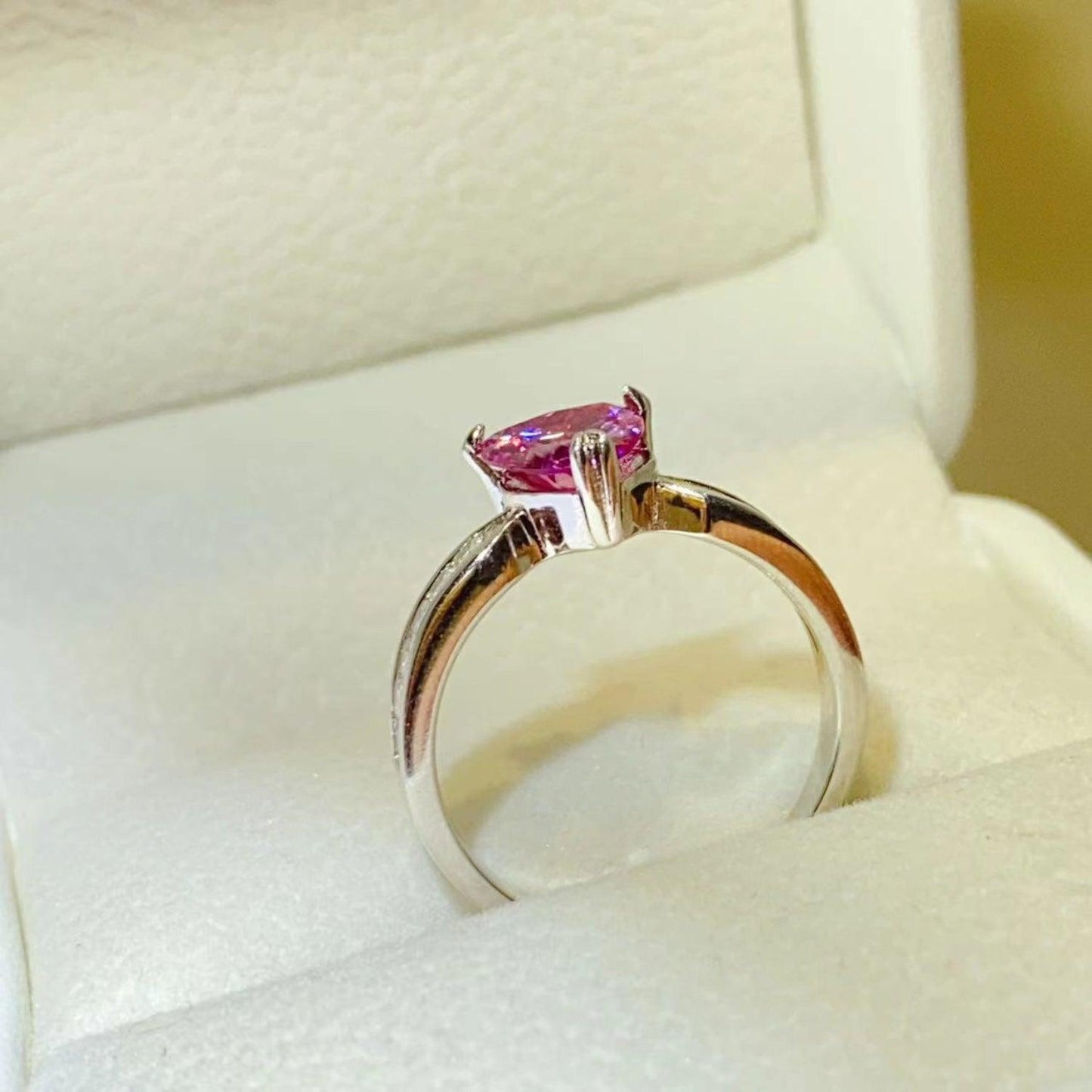 Elegant 1 Carat Moissanite 925 Sterling Silver Ring with a vibrant pink gemstone, showcased in a luxurious setting.