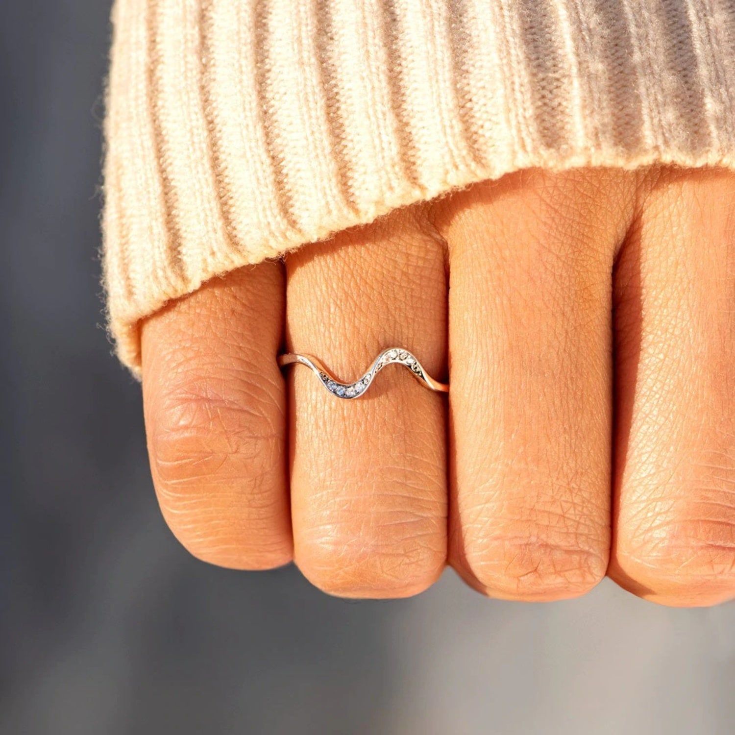 a close up of a person's hand with a ring on it