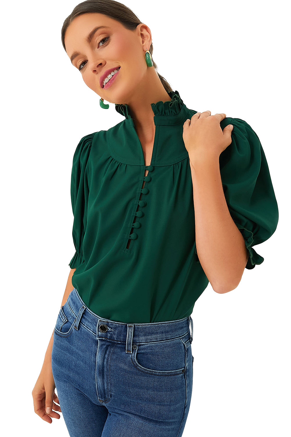 a woman wearing a green blouse and jeans