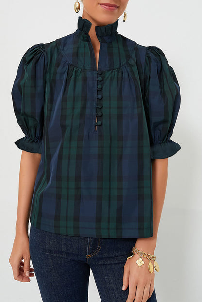 a woman wearing a black and green plaid shirt