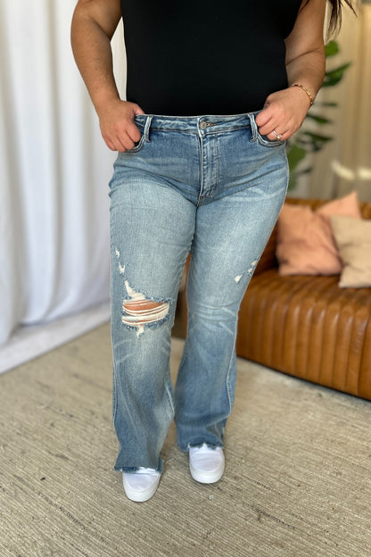 a woman standing in a living room with her hands in her pockets