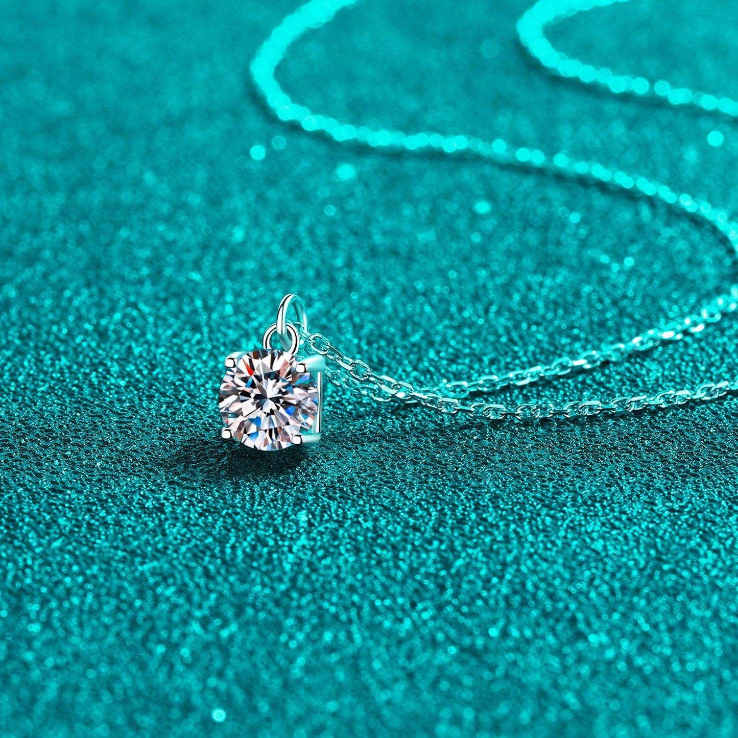 Elegant diamond pendant necklace on sparkling teal background