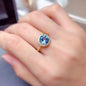 18K gold-plated artificial gemstone ring with a large blue oval-shaped stone on a female hand